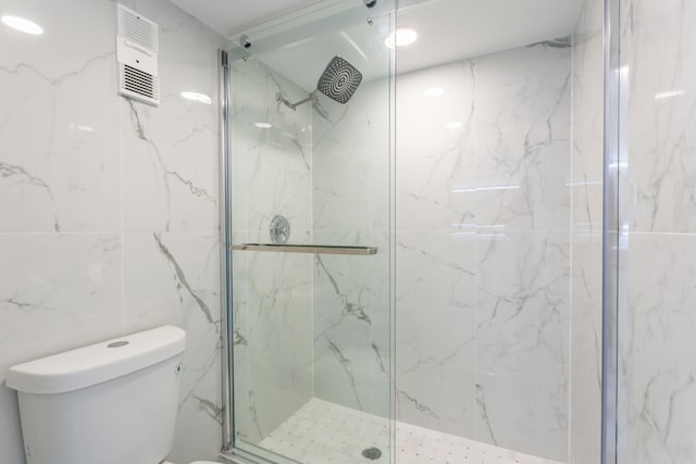 bathroom with an enclosed shower, toilet, and tile walls