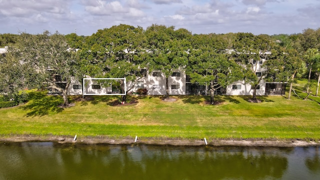 back of property with a yard and a water view