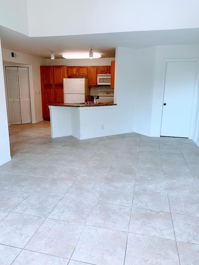 kitchen featuring kitchen peninsula and white appliances