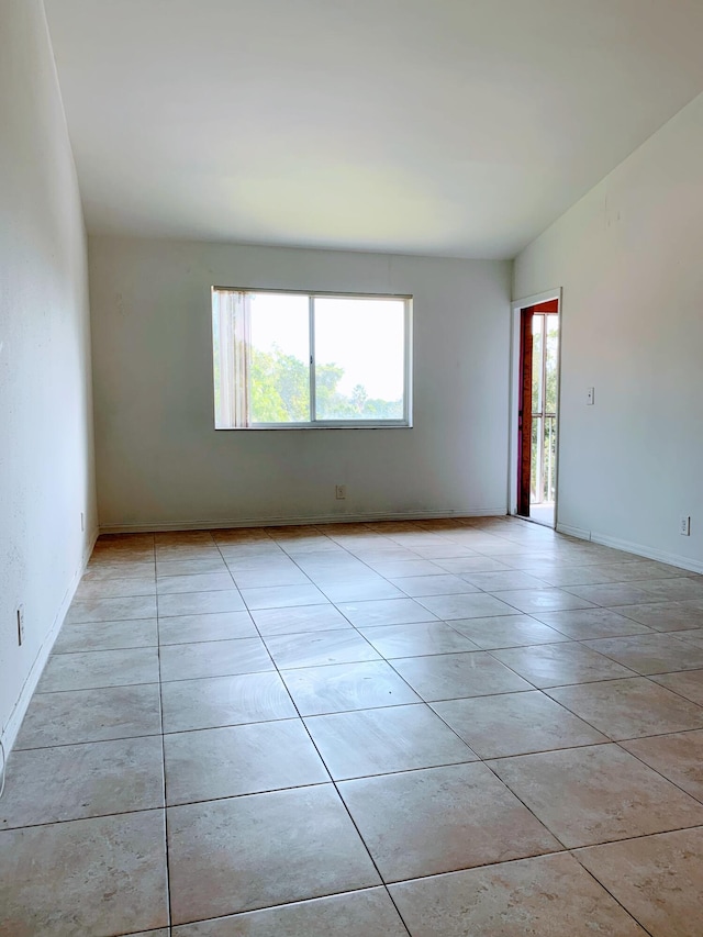 spare room featuring plenty of natural light and light tile patterned flooring