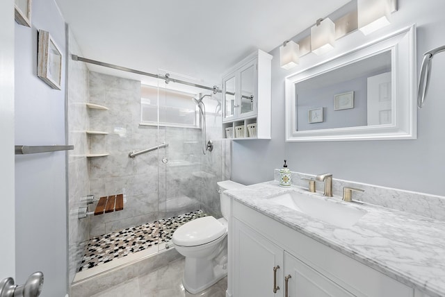 bathroom featuring toilet, vanity, and a shower with door