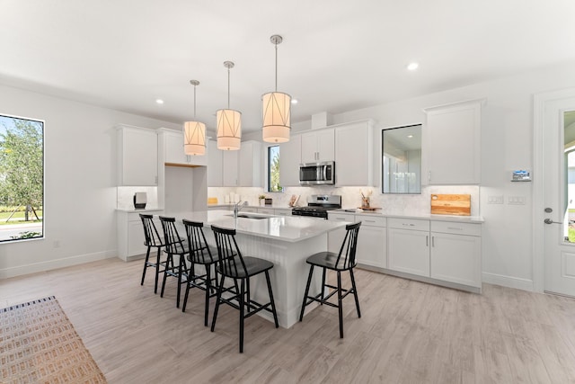 950 SW Prairie Ave, Palm City, FL 34990 - kitchen with stainless steel appliances, a sink, light wood-style flooring, backsplash, and recessed lighting