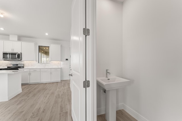 950 SW Prairie Ave, Palm City, FL 34990 - bathroom featuring wood finished floors, backsplash, baseboards, and recessed lighting