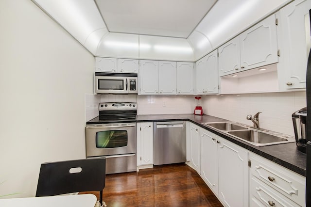 kitchen featuring sink, dark wood-type flooring, stainless steel appliances, and white cabinets