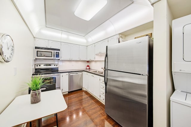 kitchen with dark wood-type flooring, sink, appliances with stainless steel finishes, decorative backsplash, and white cabinets