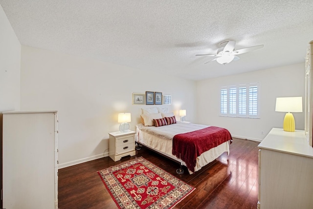 bedroom with a textured ceiling, dark hardwood / wood-style floors, and ceiling fan