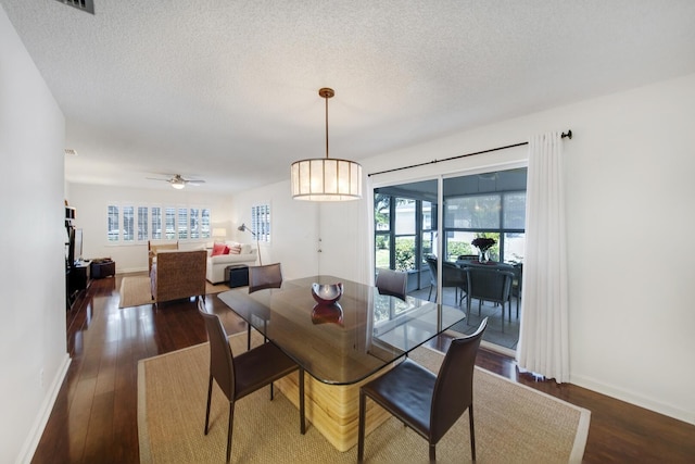 dining room featuring plenty of natural light, dark hardwood / wood-style flooring, and a textured ceiling