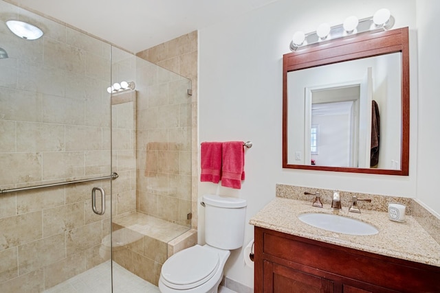 bathroom featuring an enclosed shower, vanity, and toilet