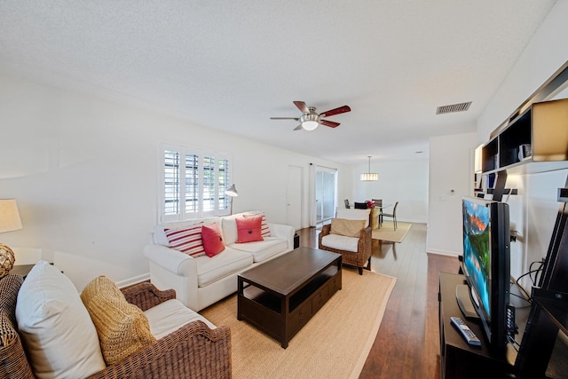 living room featuring hardwood / wood-style floors, a textured ceiling, and ceiling fan