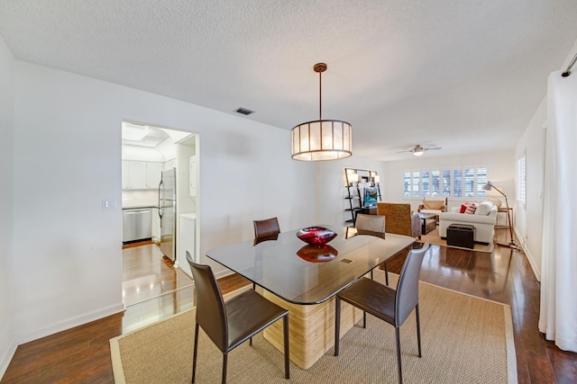 dining room with ceiling fan, dark hardwood / wood-style floors, and a textured ceiling