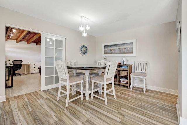 dining area with light hardwood / wood-style flooring, wooden ceiling, and beam ceiling