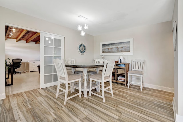dining room featuring light wood-style floors, a desk, and baseboards
