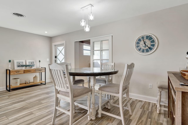dining area with light wood-type flooring, baseboards, and recessed lighting