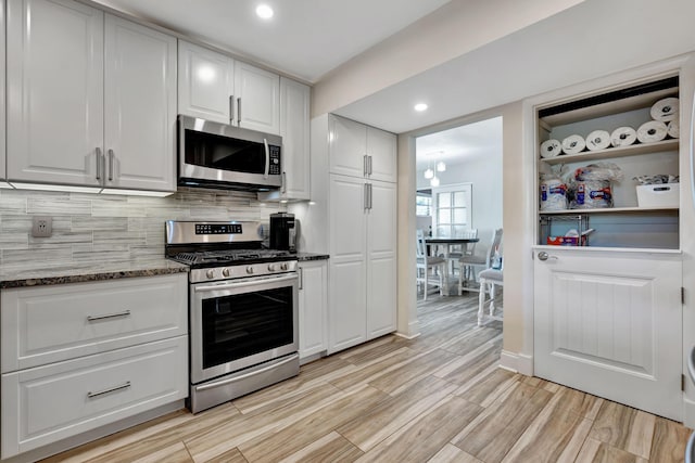 kitchen with stainless steel appliances, white cabinetry, tasteful backsplash, light wood-style floors, and recessed lighting