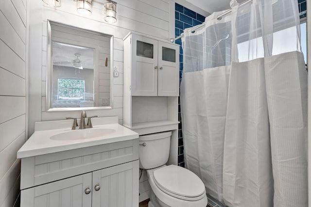 bathroom featuring toilet, walk in shower, vanity, and ceiling fan