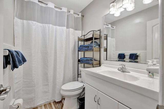 bathroom featuring toilet, vanity, wood finished floors, and a shower with shower curtain