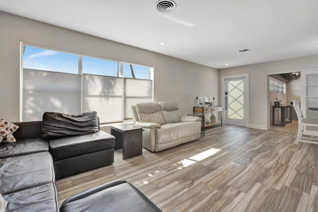 living room with light wood-type flooring, recessed lighting, and baseboards