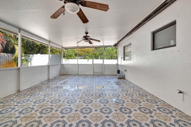 unfurnished sunroom with a ceiling fan and healthy amount of natural light