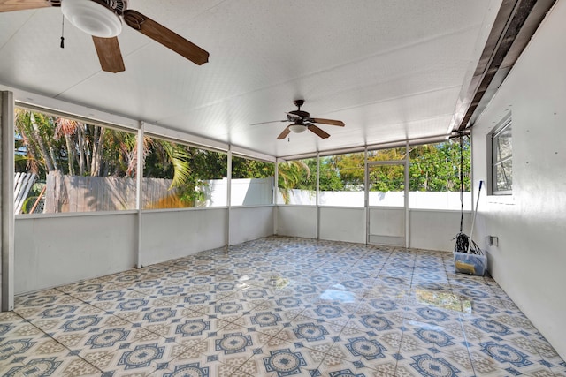 unfurnished sunroom with a ceiling fan and plenty of natural light