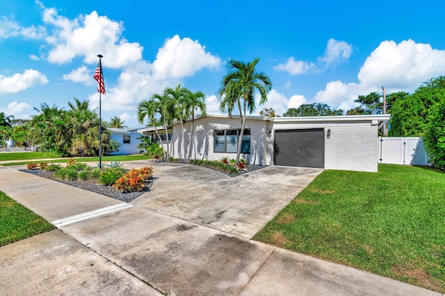 view of front of house with an attached garage, concrete driveway, a gate, and brick siding