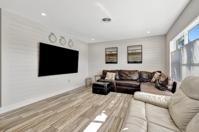 living room with wooden walls, wood finished floors, and recessed lighting