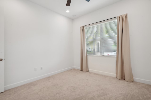 carpeted spare room with ceiling fan