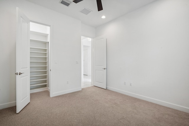 unfurnished bedroom with light carpet, a closet, and ceiling fan