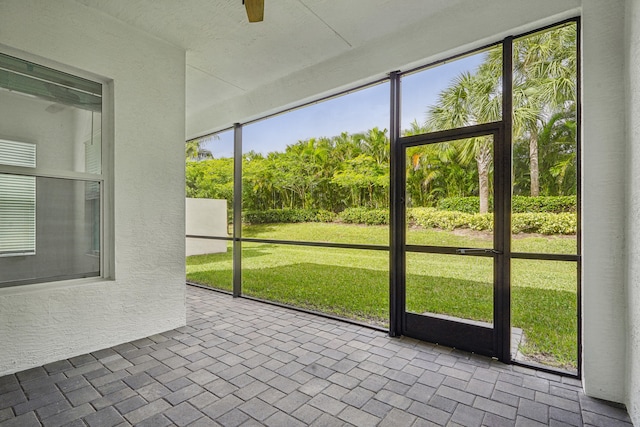 unfurnished sunroom featuring ceiling fan