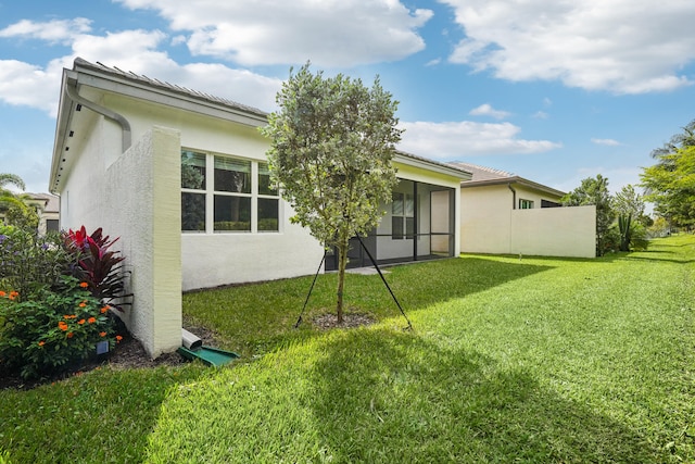 back of property featuring a sunroom and a yard