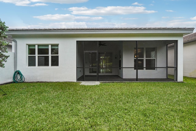 rear view of house with a sunroom and a yard