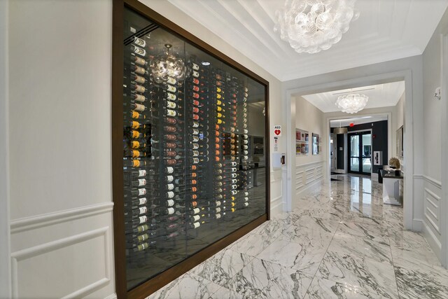 wine room with french doors, ornamental molding, and a notable chandelier