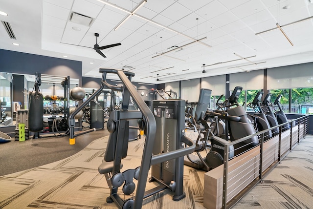 exercise room with light colored carpet and ceiling fan