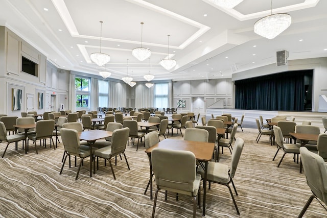 dining space featuring light carpet, a tray ceiling, and a chandelier