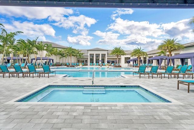 view of swimming pool with a community hot tub and a patio area