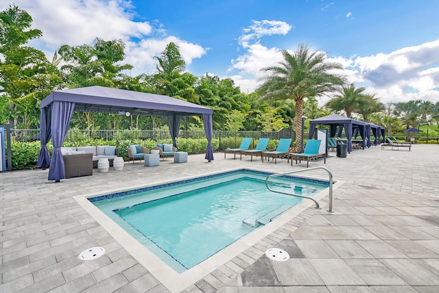 view of swimming pool with a patio, an outdoor living space, and a gazebo