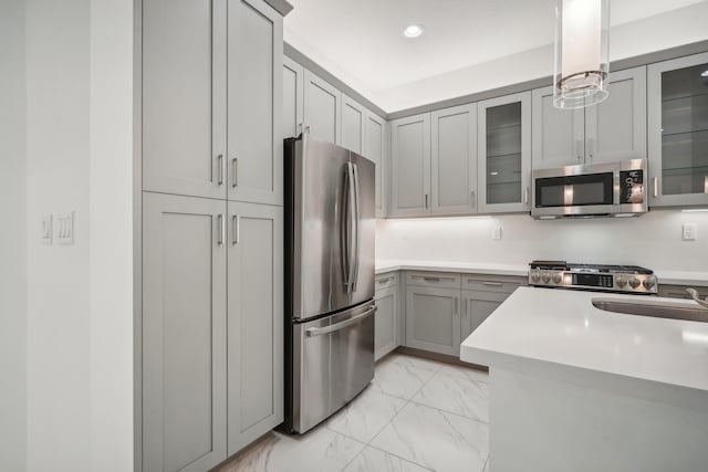 kitchen with sink, decorative light fixtures, gray cabinets, and appliances with stainless steel finishes