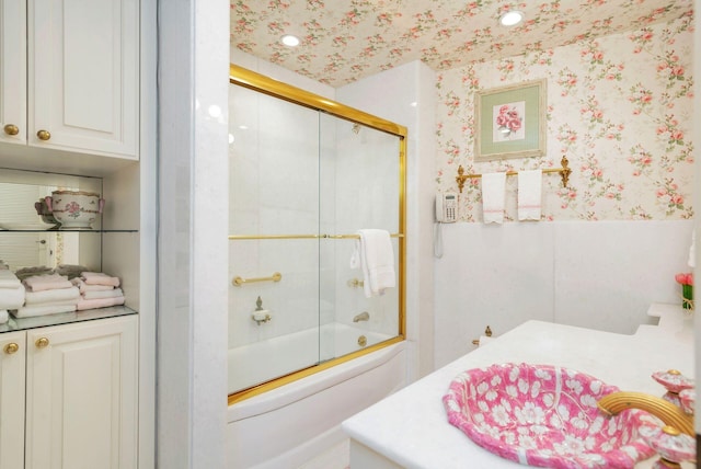 bathroom with combined bath / shower with glass door and vanity