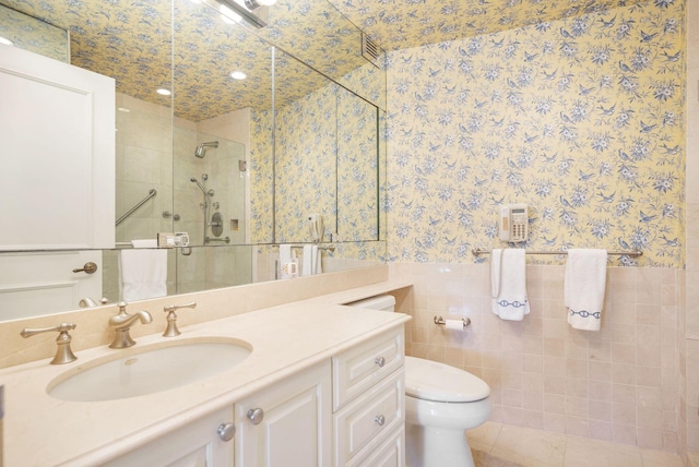 bathroom with tile walls, tile patterned floors, walk in shower, vanity, and toilet