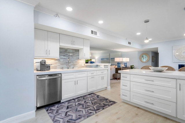 kitchen featuring white cabinetry, ornamental molding, stainless steel dishwasher, and hanging light fixtures