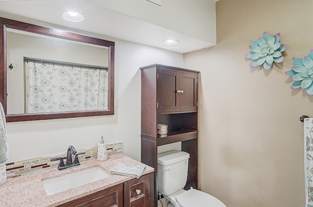 bathroom with decorative backsplash, vanity, toilet, and walk in shower