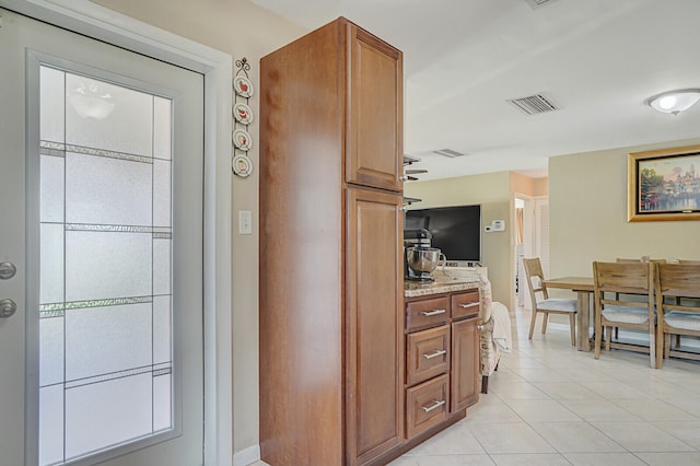 kitchen with light stone countertops, light tile patterned floors, and a healthy amount of sunlight