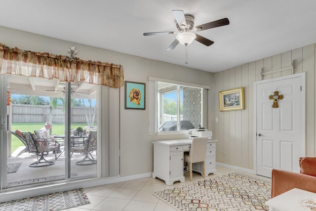 office space featuring wood walls, ceiling fan, and light tile patterned flooring