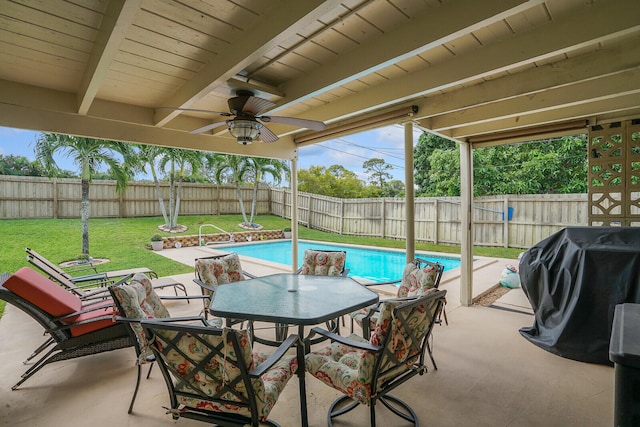 view of pool with area for grilling, ceiling fan, a patio area, and a lawn