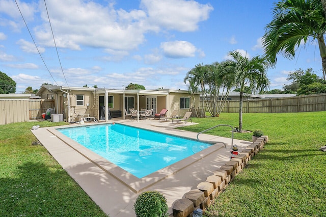 view of pool with a lawn and a patio