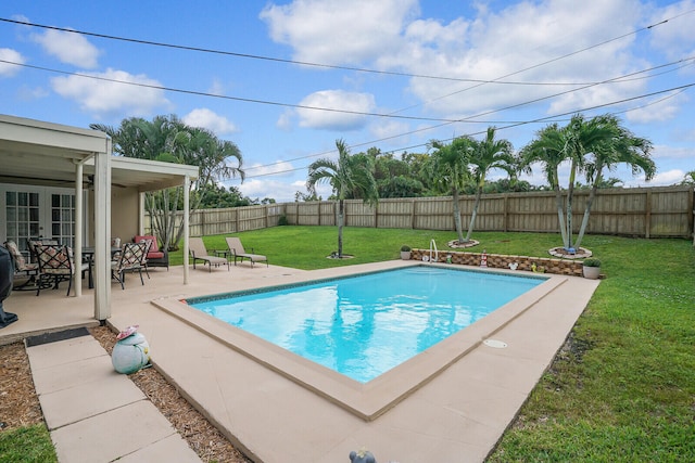 view of pool with a patio area and a lawn