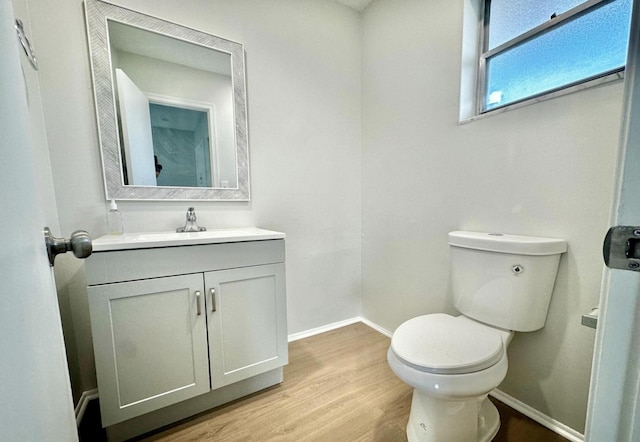 bathroom featuring hardwood / wood-style flooring, vanity, and toilet