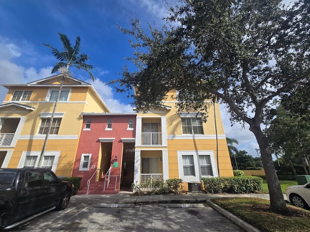 view of front of house with a balcony and central AC