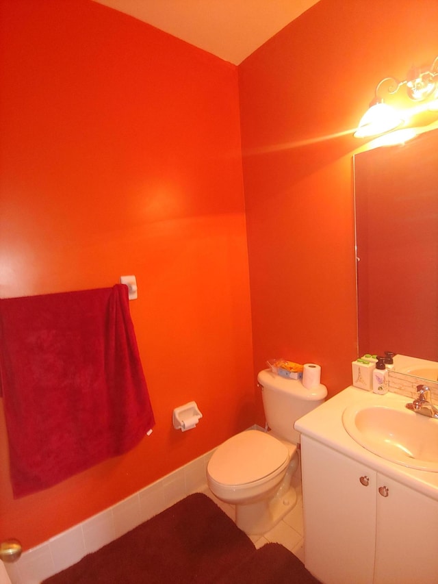 bathroom with toilet, vanity, and tile patterned floors