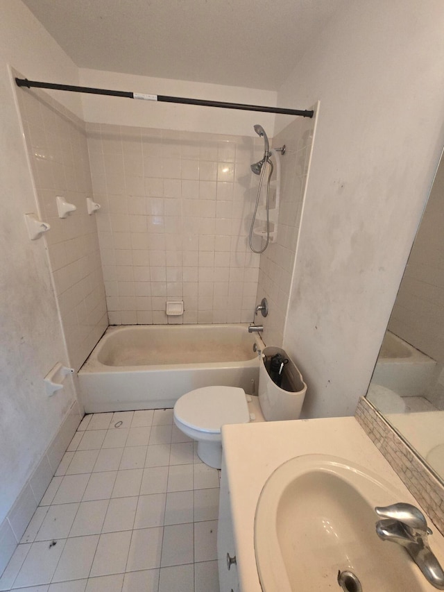 full bathroom featuring toilet, tiled shower / bath combo, vanity, and tile patterned floors