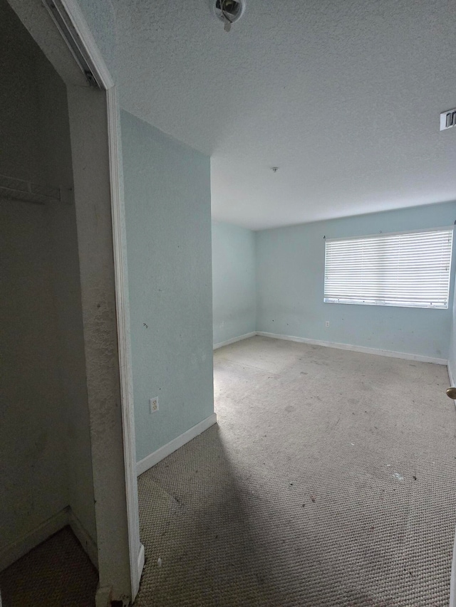 empty room featuring carpet and a textured ceiling